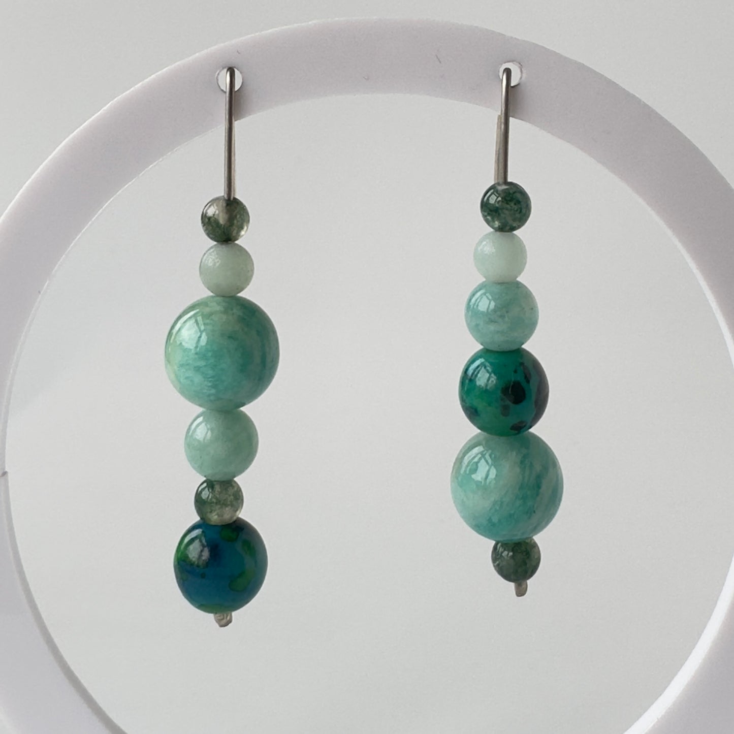 Pair of beaded earrings with green beads on a white background