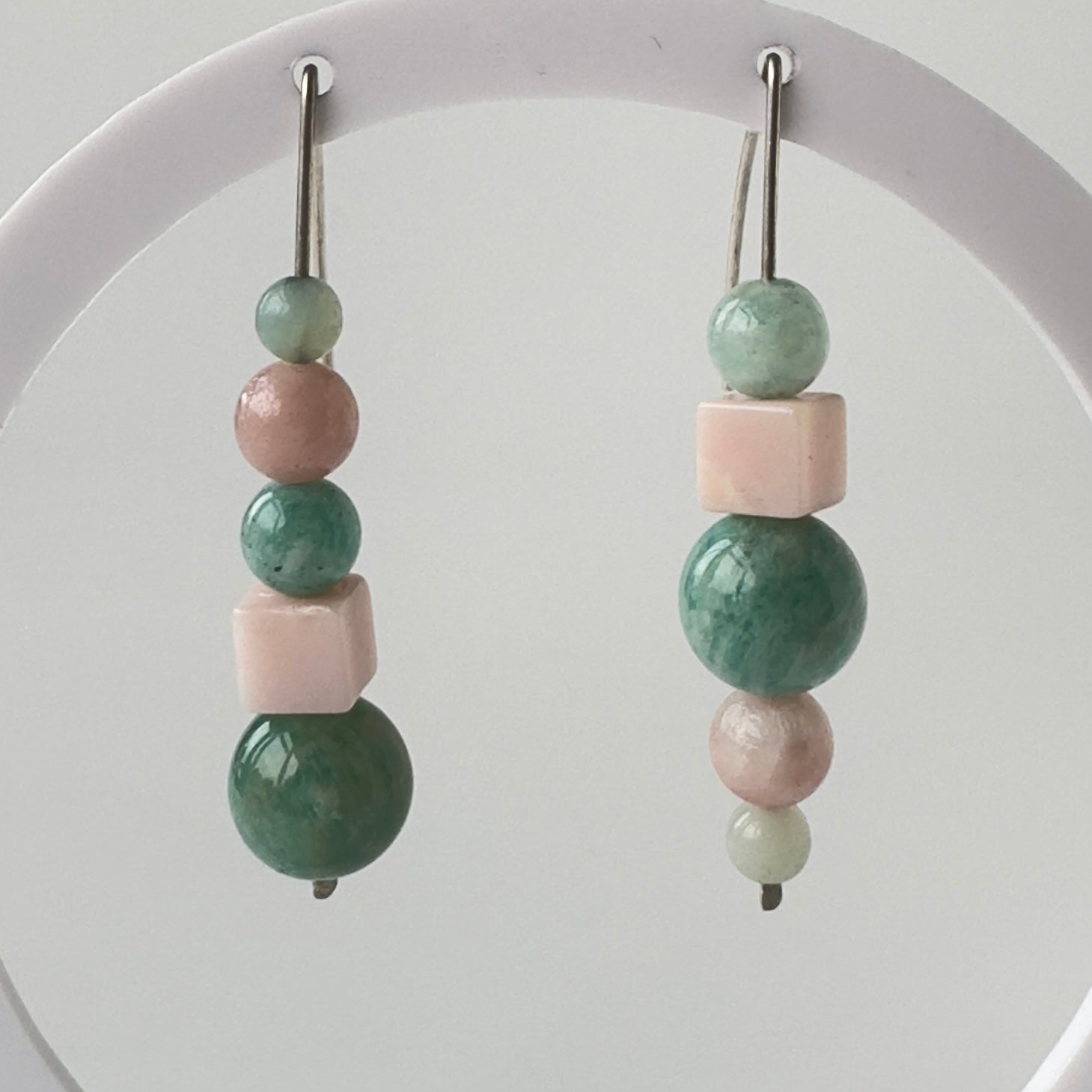 Beaded earrings with green and pink beads on a white background