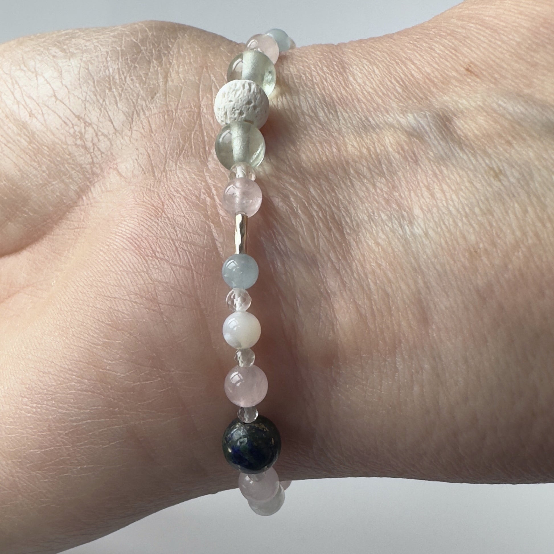 Aquarius Birthstone Healing Crystal bracelet for Calm & Anxiety Relief showing Aquamarine, Fluorite, Moonstone, Azurite, Rose Quartz and Lava Stone on a wrist