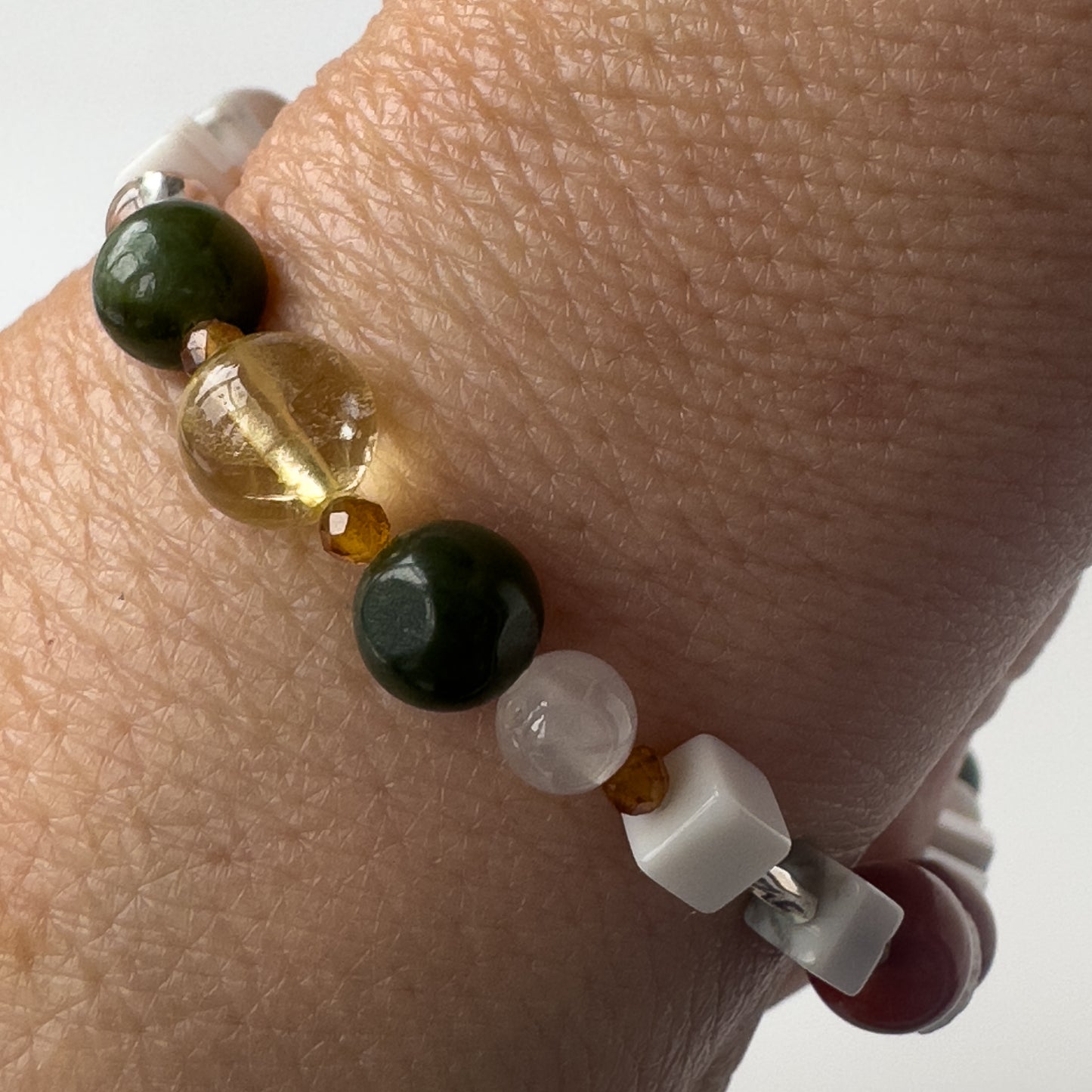 Aries Birthstone Healing Crystal bracelet for Love and Compassion on wrist showing Citrine, Garnet, Howlite, Jade and Selenite