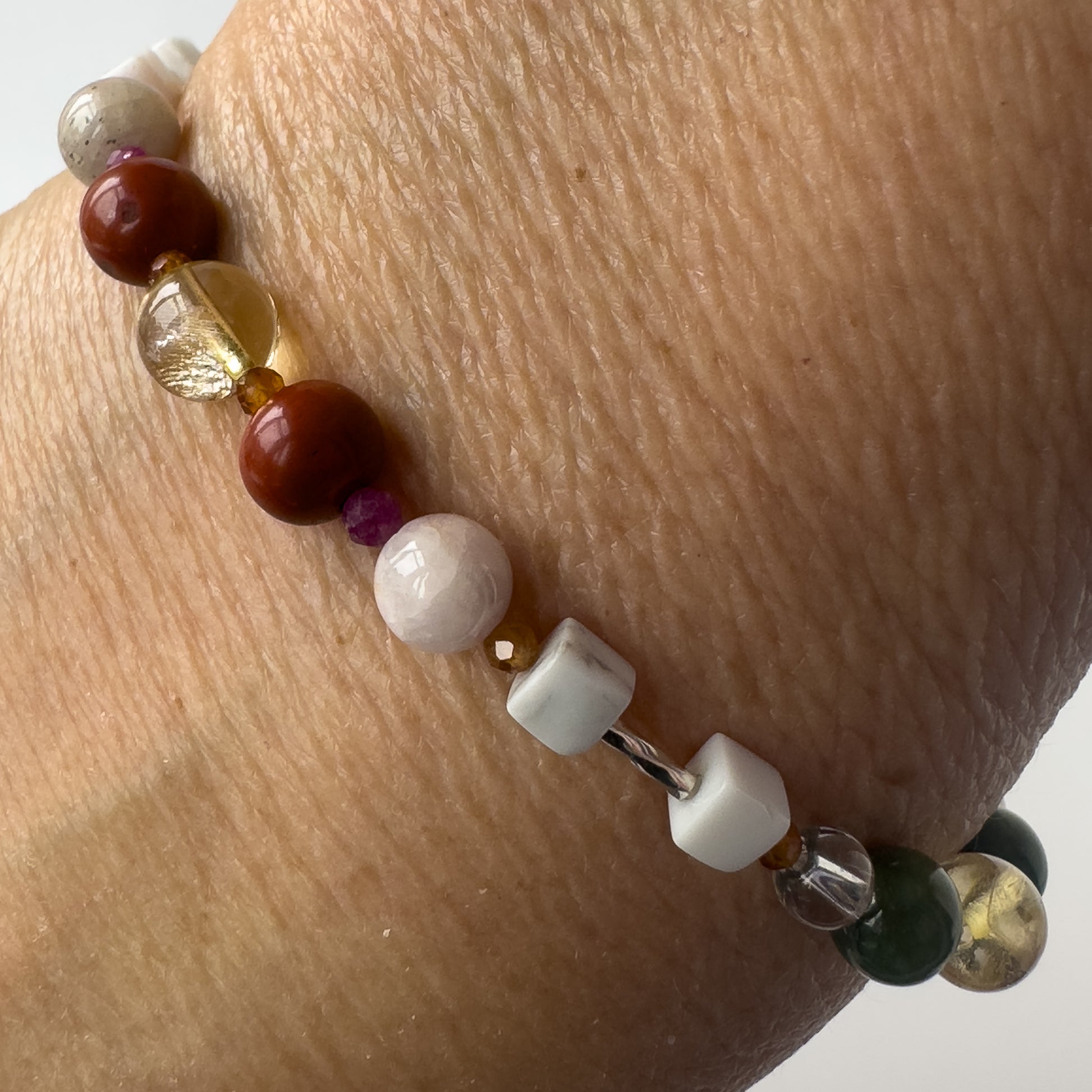 Aries Birthstone Healing Crystal bracelet for Love and Compassion on wrist showing Citrine, Garnet, Howlite, Red Jasper, Kunzite and Ruby