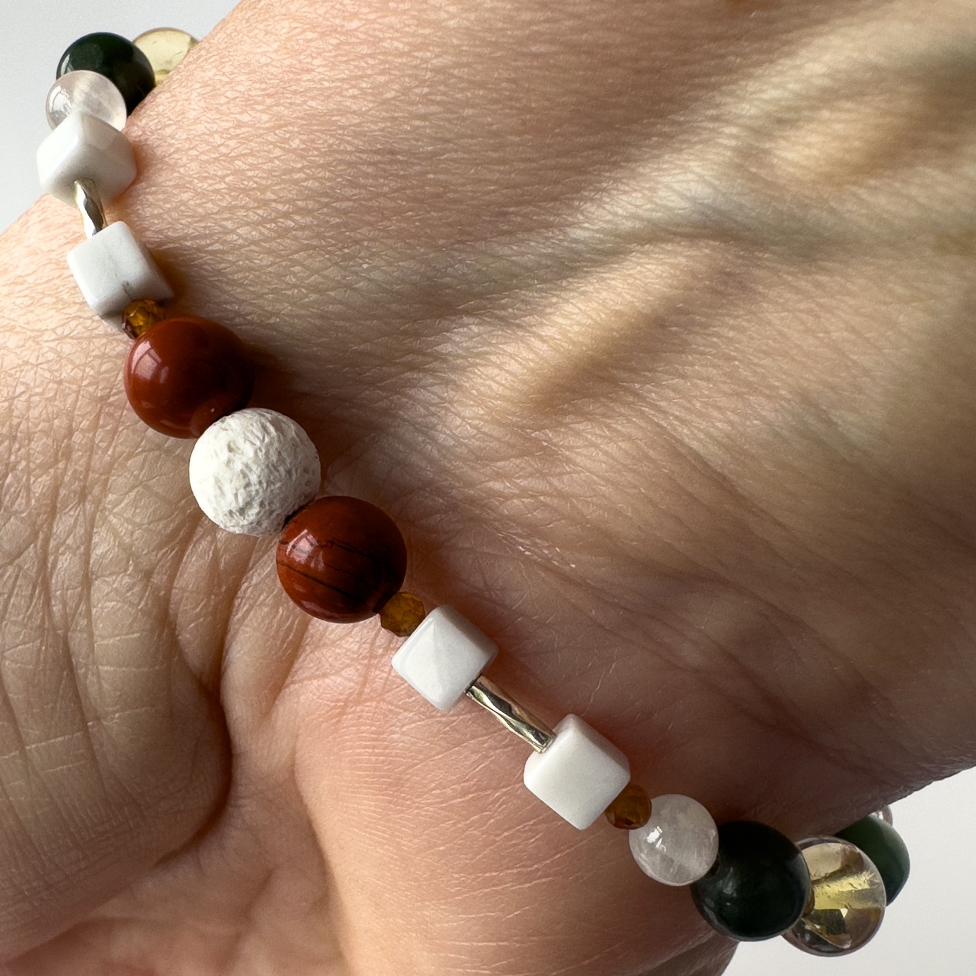 Aries Birthstone Healing Crystal bracelet for Love and Compassion on wrist showing Garnet, Howlite, Red Jasper and Lava Stone