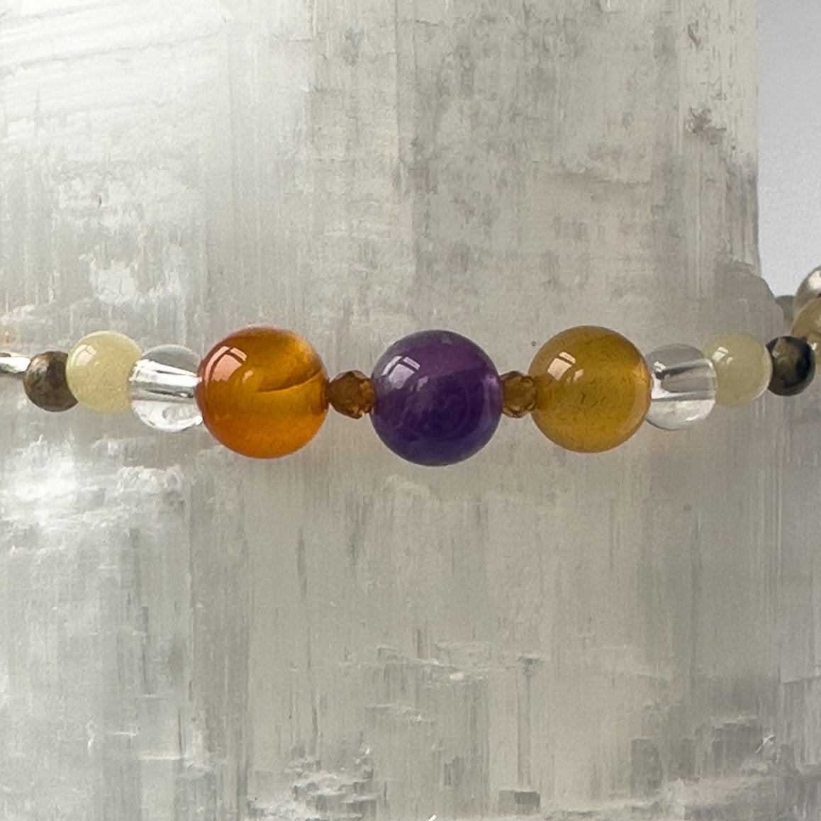 Aries Birthstone Healing Crystal bracelet for Determination & Willpower Close-up of Amethyst, Leopardskin Jasper, Aragonite, Garnet, Carnelian and Clear Quartz