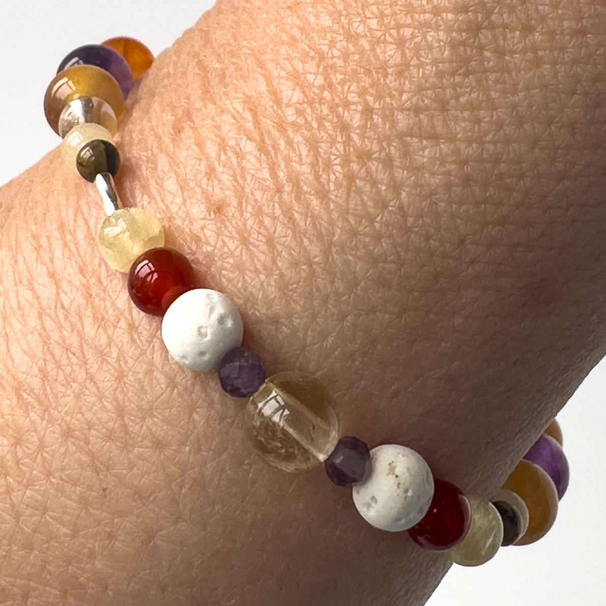 Aries Birthstone Healing Crystal bracelet for Determination & Willpower Close-up on wrist showing Amethyst, Aragonite, Citrine, Carnelian and Lava Stone