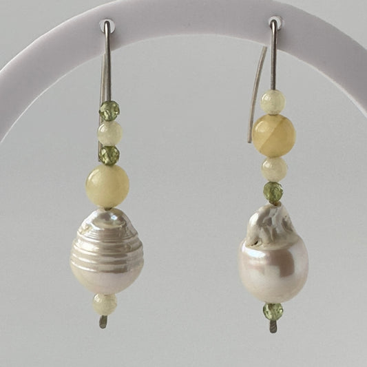 Pair of earrings with pearls and green beads on a gray background