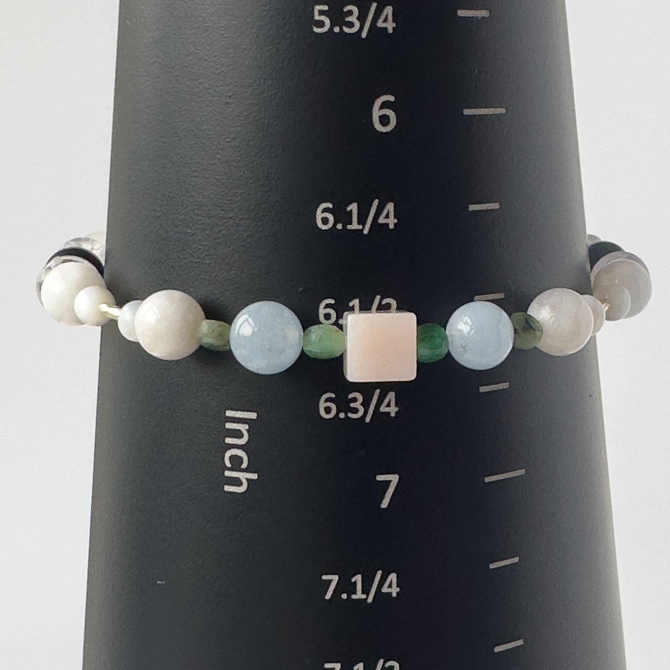 Cancer birthstone Healing Crystal bracelet for Calm & Stress relief on mandrel showing Moonstone, Emerald, Aquamarine, Pink Opal and showing size as 6.5 inches