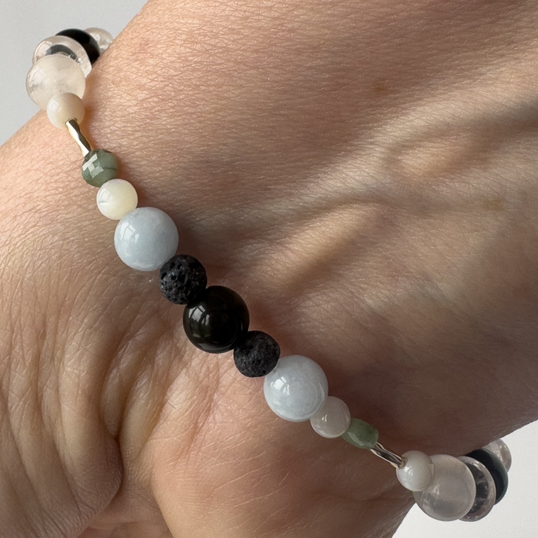 Cancer birthstone Healing Crystal bracelet for Calm & Stress relief on wrist showing Moonstone, Emerald, Aquamarine, Obsidian and Lava Stone