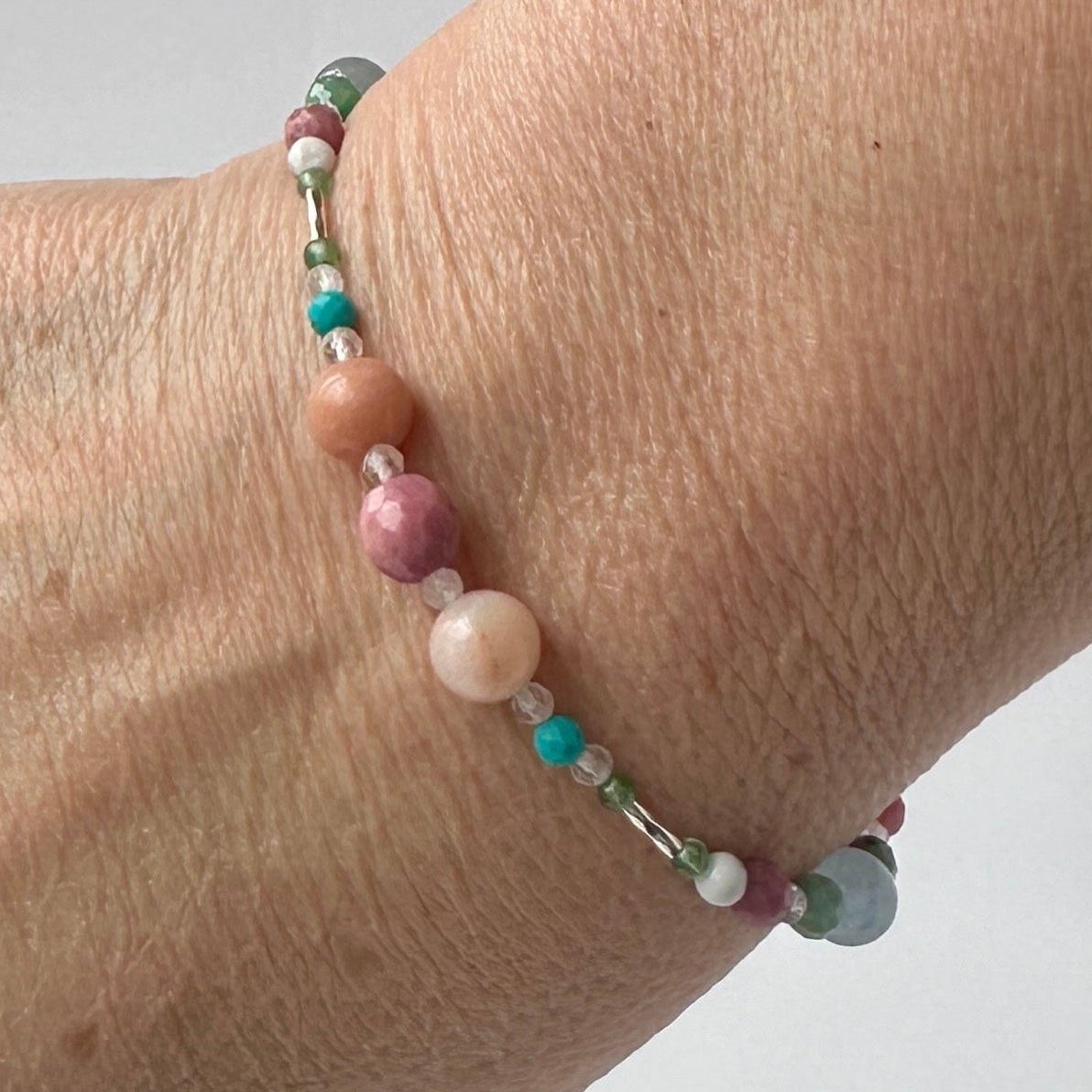 Cancer Healing Crystal bracelet for Anxiety on wrist showing Rhodonite, Turquoise, Aquamarine, Aventurine, Howlite and Clear Quartz