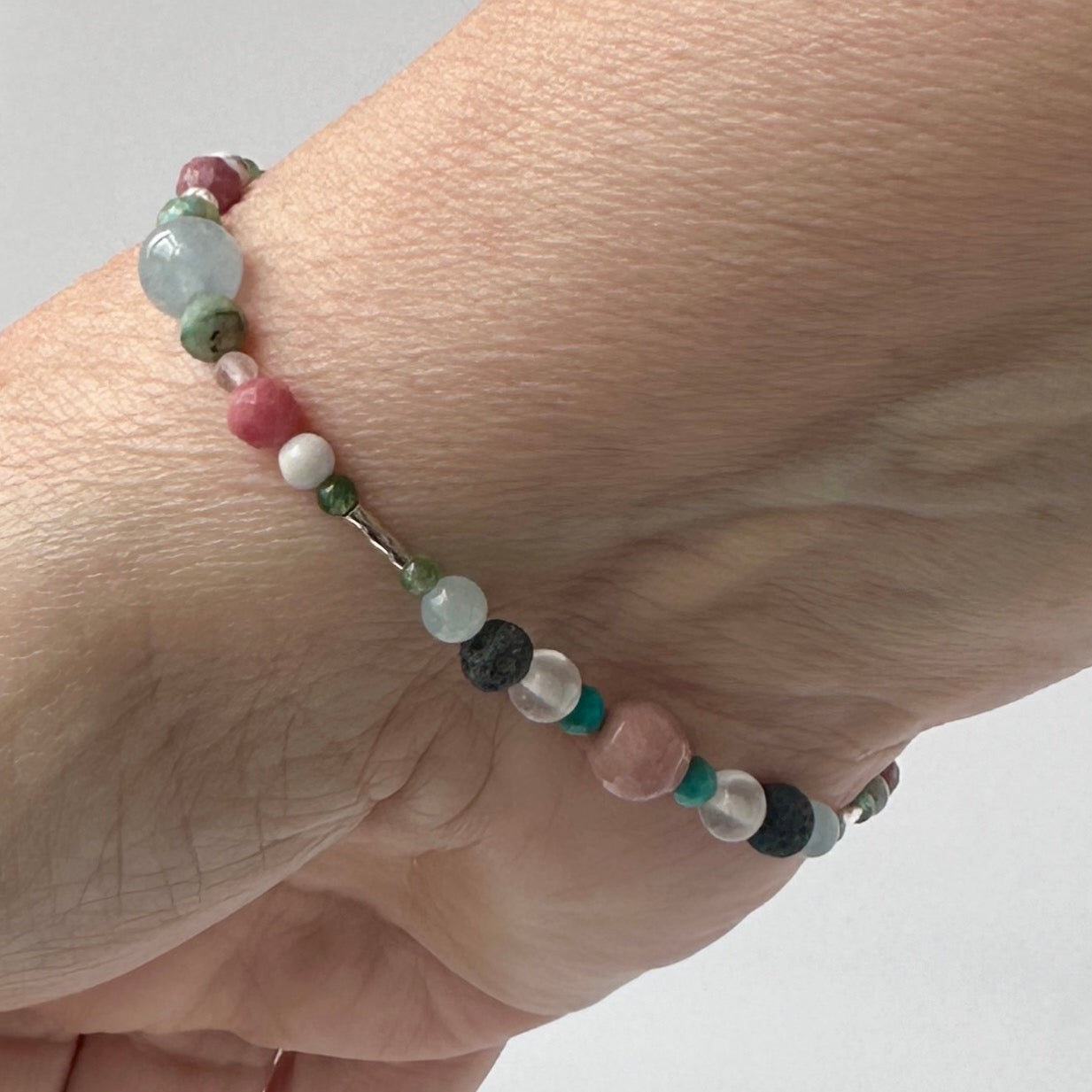 Cancer Birthstone Healing Crystal bracelet for Calm & Anxiety Relief on wrist showing Chrysocolla, Rhodonite, Turquoise, Aquamarine, Aventurine, Howlite, Selenite and Lava Stone