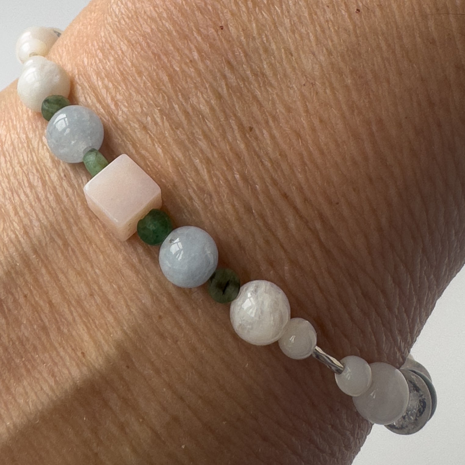 Cancer Healing Crystal bracelet for Stress on wrist showing Moonstone, Emerald, Aquamarine and Pink Opal