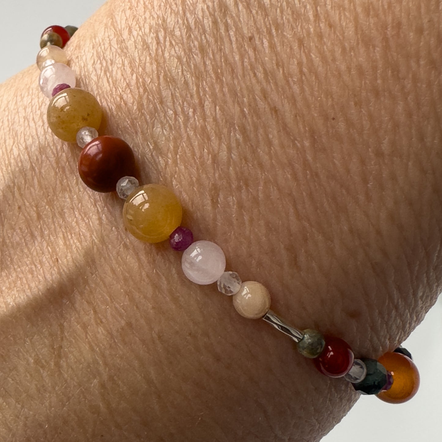 Cancer Birthstone Healing Crystal bracelet for Determination & Willpower on wrist showing Red Jasper, Ruby, Carnelian, Rose Quartz, Sunstone and Clear Quartz