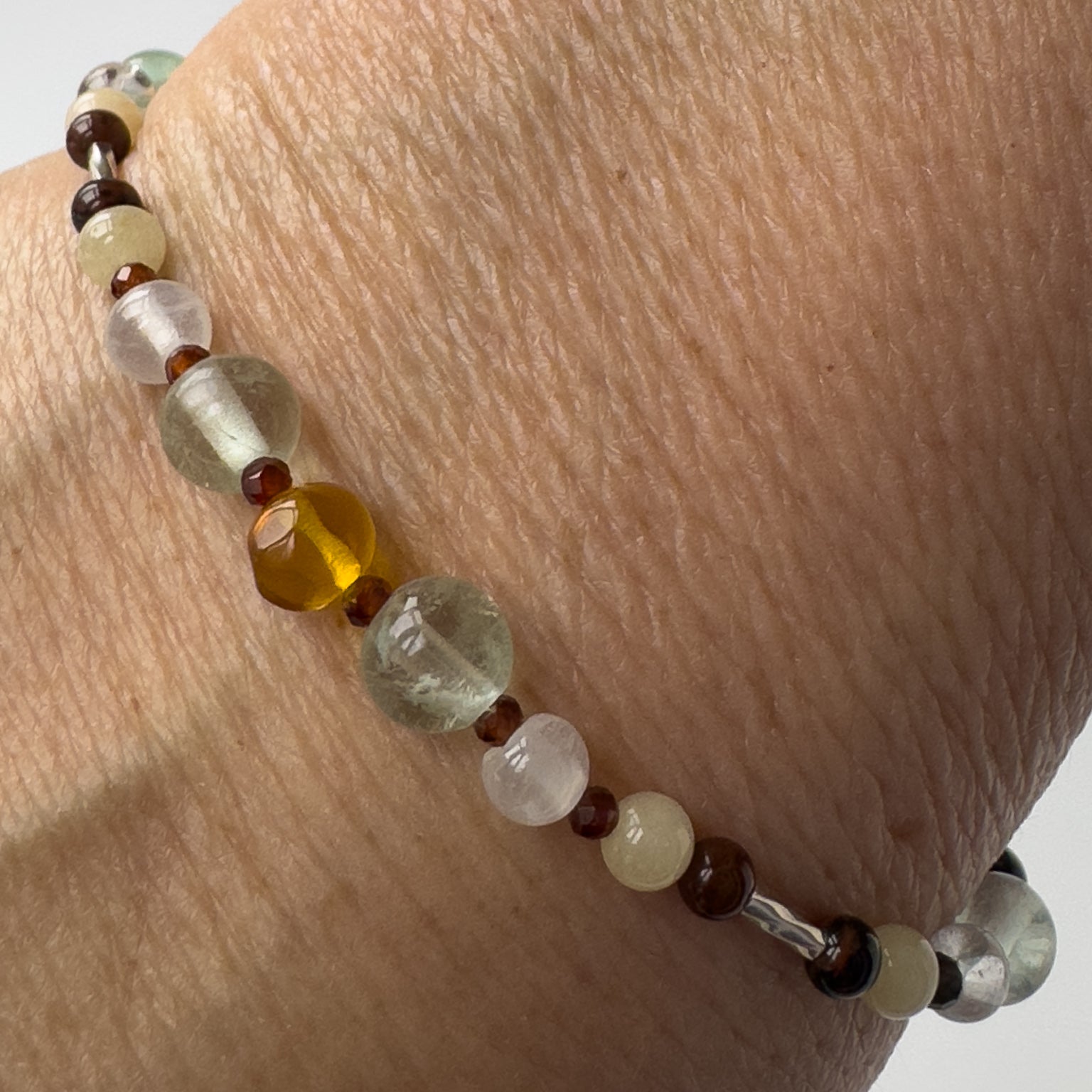 Capricorn Healing Crystal bracelet for Confidence on wrist showing Garnet, Mahogany Obsidian, Amber, Fluorite and Aragonite