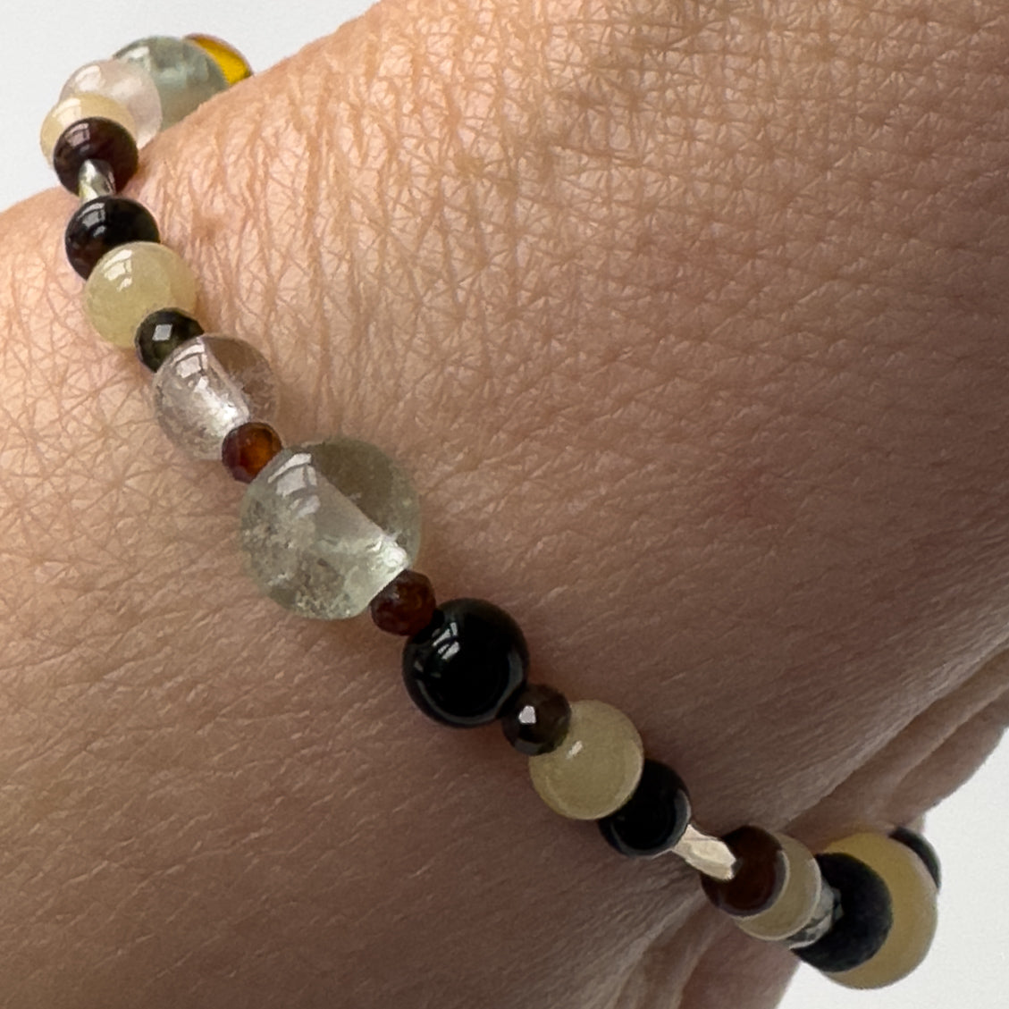 Capricorn Healing Crystal bracelet for Confidence and Self-esteem on wrist showing Garnet, Obsidian, Mahogany Obsidian, Fluorite and Aragonite