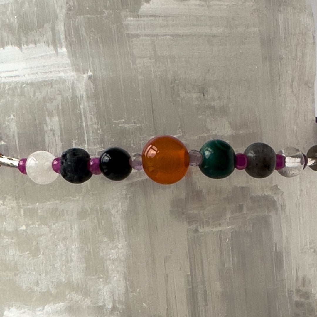 Capricorn Birthstone Healing Crystal bracelet for Grief & Loss support showing Onyx, Malachite, Labradorite, Amethyst, Ruby, Carnelian, Azurite, Selenite, Clear Quartz and Lava Stone