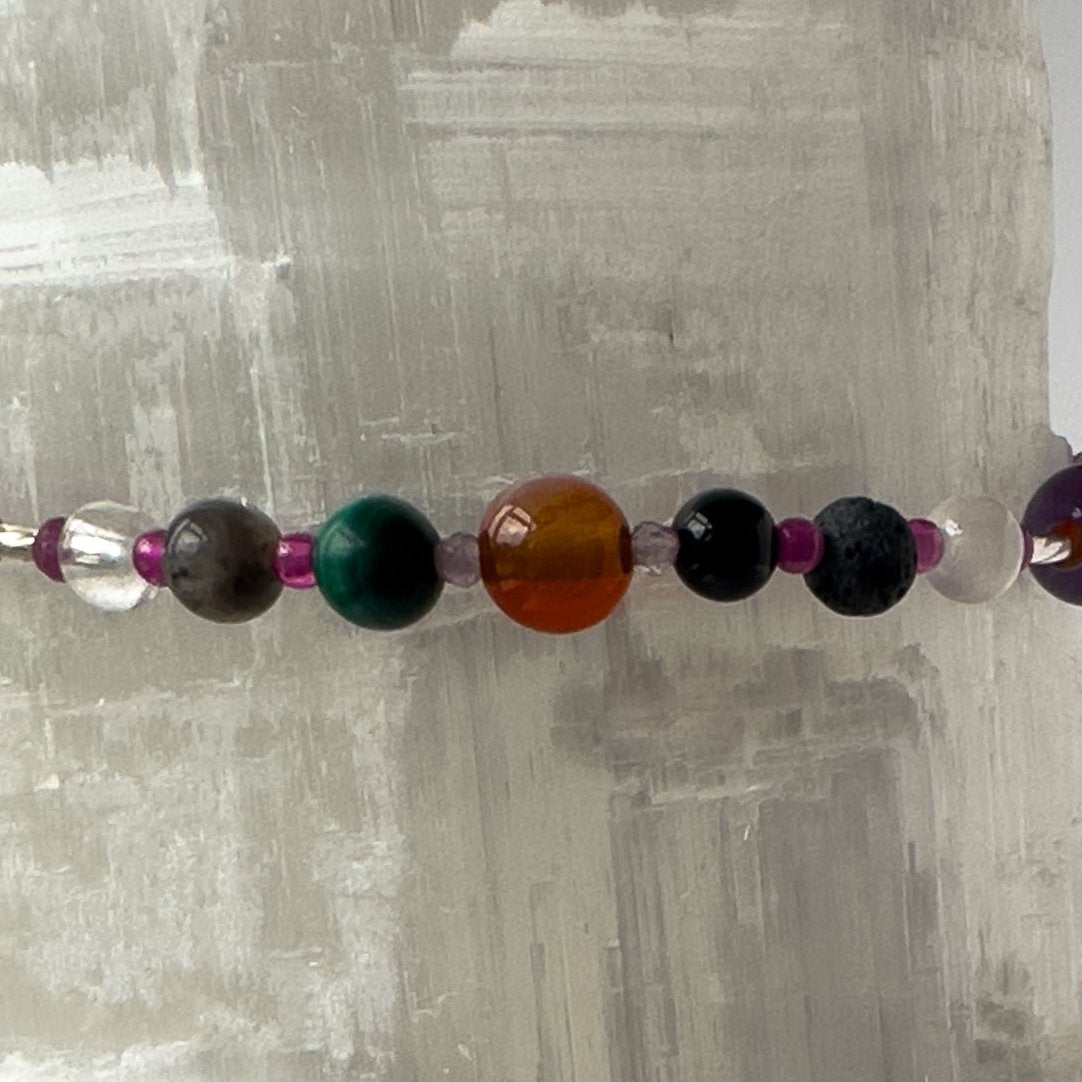 Capricorn Birthstone Healing Crystal bracelet for Grief & Loss support showing Onyx, Malachite, Labradorite, Ruby, Carnelian, Azurite, Selenite, Clear Quartz and Lava Stone.