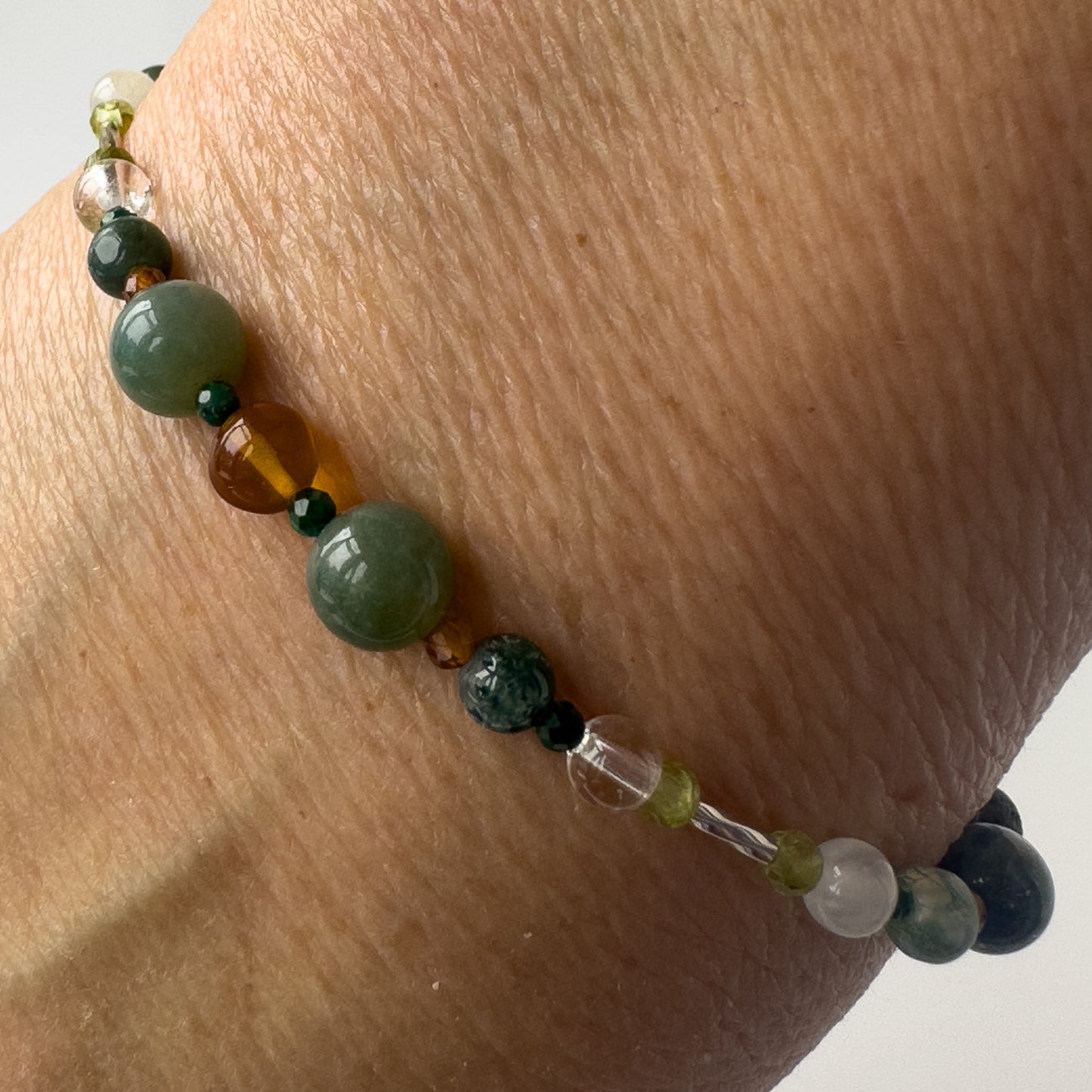 Capricorn Healing Crystal bracelet for Love on wrist showing Amber, Moss Agate, Garnet, Malachite and Clear Quartz
