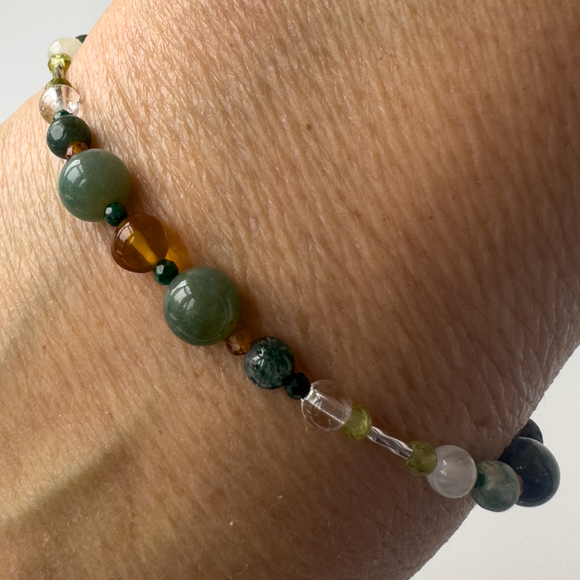 Capricorn Healing Crystal bracelet for Love on wrist showing Amber, Moss Agate, Garnet, Malachite and Clear Quartz