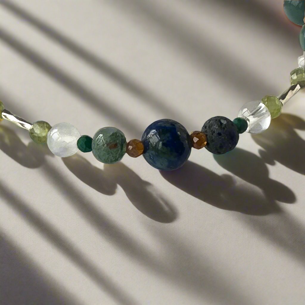 Capricorn Birthstone Healing Crystal bracelet for Love and Compassion showing Peridot, Moss Agate, Azurite, Garnet, Malachite, Lava Stone, Selenite and Clear Quartz