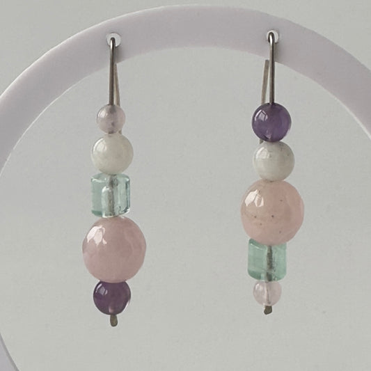 Beaded earrings with pink, green, and purple beads on a white background