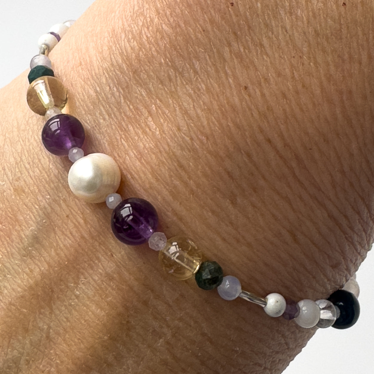 Gemini Healing Crystal bracelet for Anxiety on wrist showing Moonstone, Howlite, Blue Lace Agate, Chrysocolla, Pearl, Citrine and Amethyst
