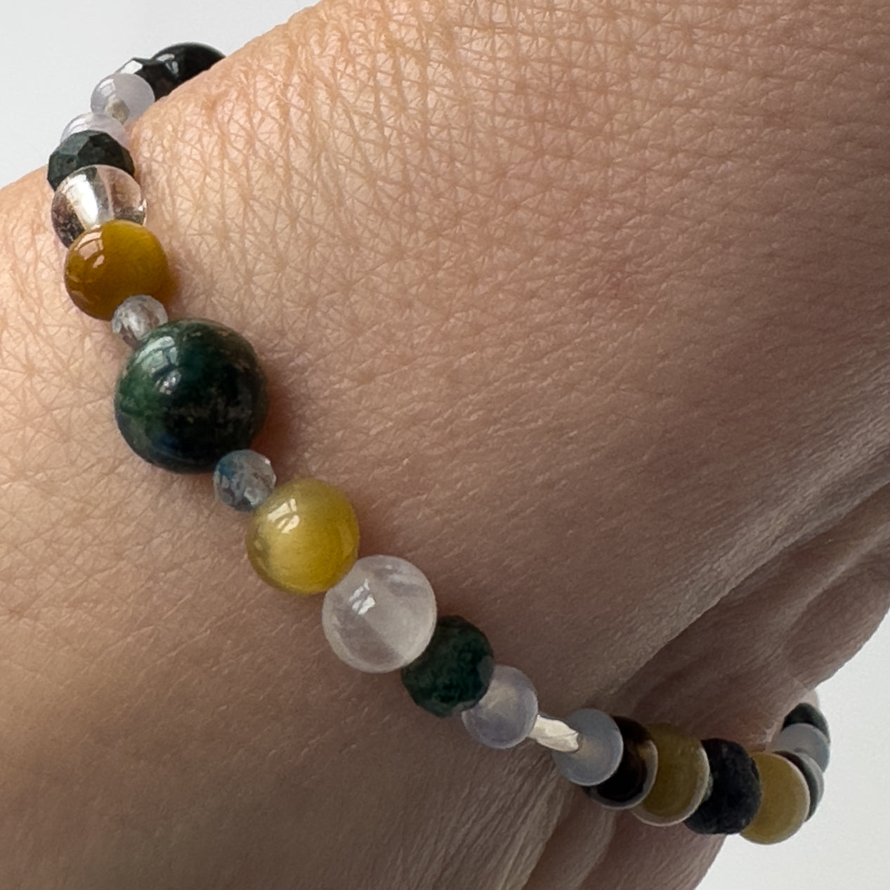 Gemini Birthstone Healing Crystal bracelet for Confidence and Self-esteem Showing Yellow Tiger’s Eye, Blue Lace Agate, Chrysocolla, Topaz, Selenite and Clear Quartz on a wrist