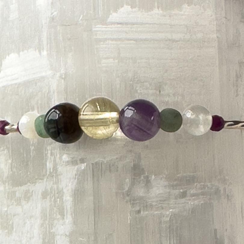 Gemini birthstone Healing Crystal bracelet for Grief & Loss support showing Emerald, Blue Tiger’s Eye, Citrine, Amethyst, Sugilite, Selenite and Clear Quartz