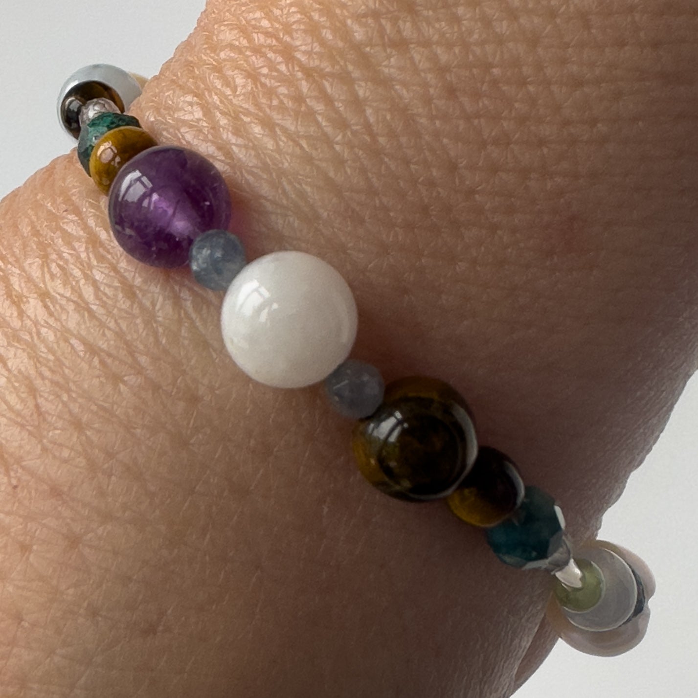 Gemini birthstone Healing Crystal bracelet for Calm & Stress relief on wrist showing Moonstone, Blue Tiger’s Eye, Yellow Tiger’s Eye, Chrysocolla, Amethyst and Sapphire