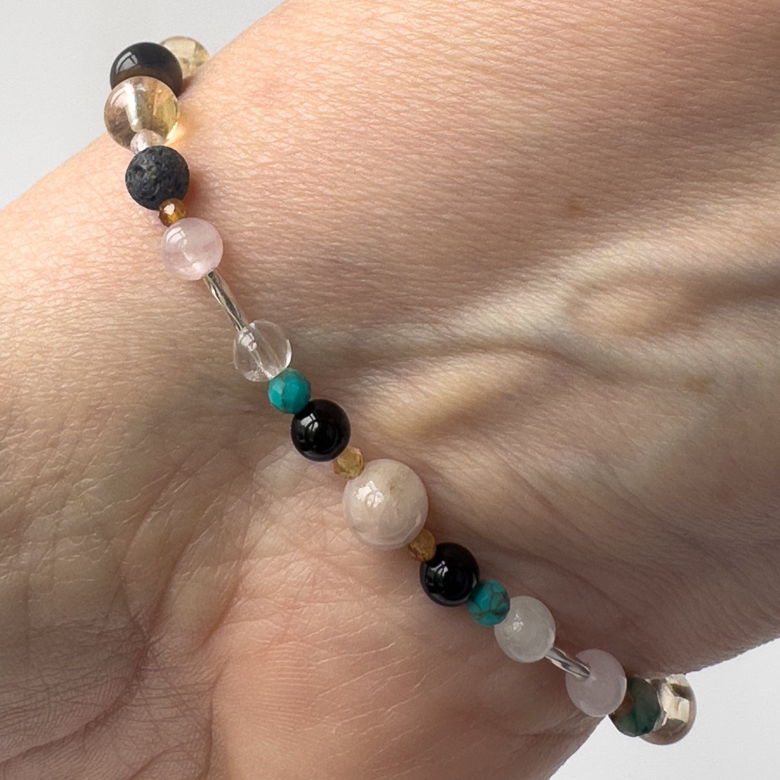 Leo Birthstone Healing Crystal bracelet for Calm & Anxiety Relief on wrist showing Turquoise, Chrysocolla, Blue Tiger’s Eye, Kunzite, Onyx, Rose Quartz, Citrine and Garnet