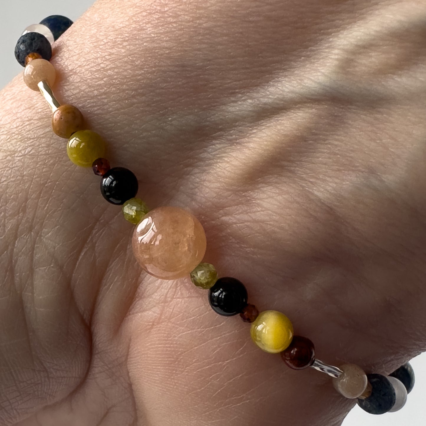 Leo Birthstone Healing Crystal bracelet for Confidence and Self-esteem on wrist showing Peridot, Yellow Tiger’s Eye, Black Onyx, Jasper, Garnet and Sunstone