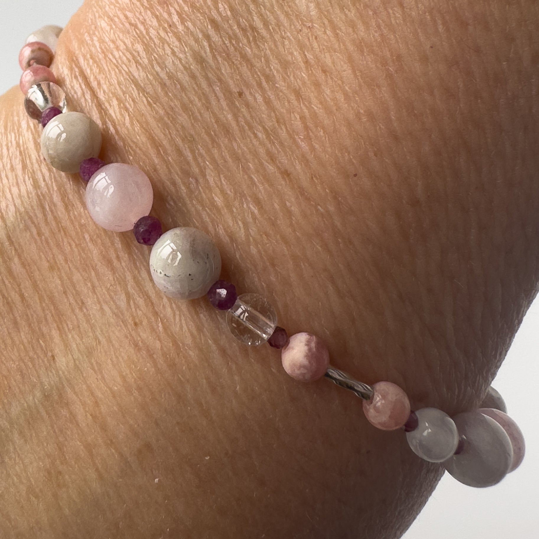 Leo Healing Crystal bracelet for Love on wrist showing Rose Quartz, Garnet, Kunzite, Rhodochrosite, Ruby and Clear Quartz