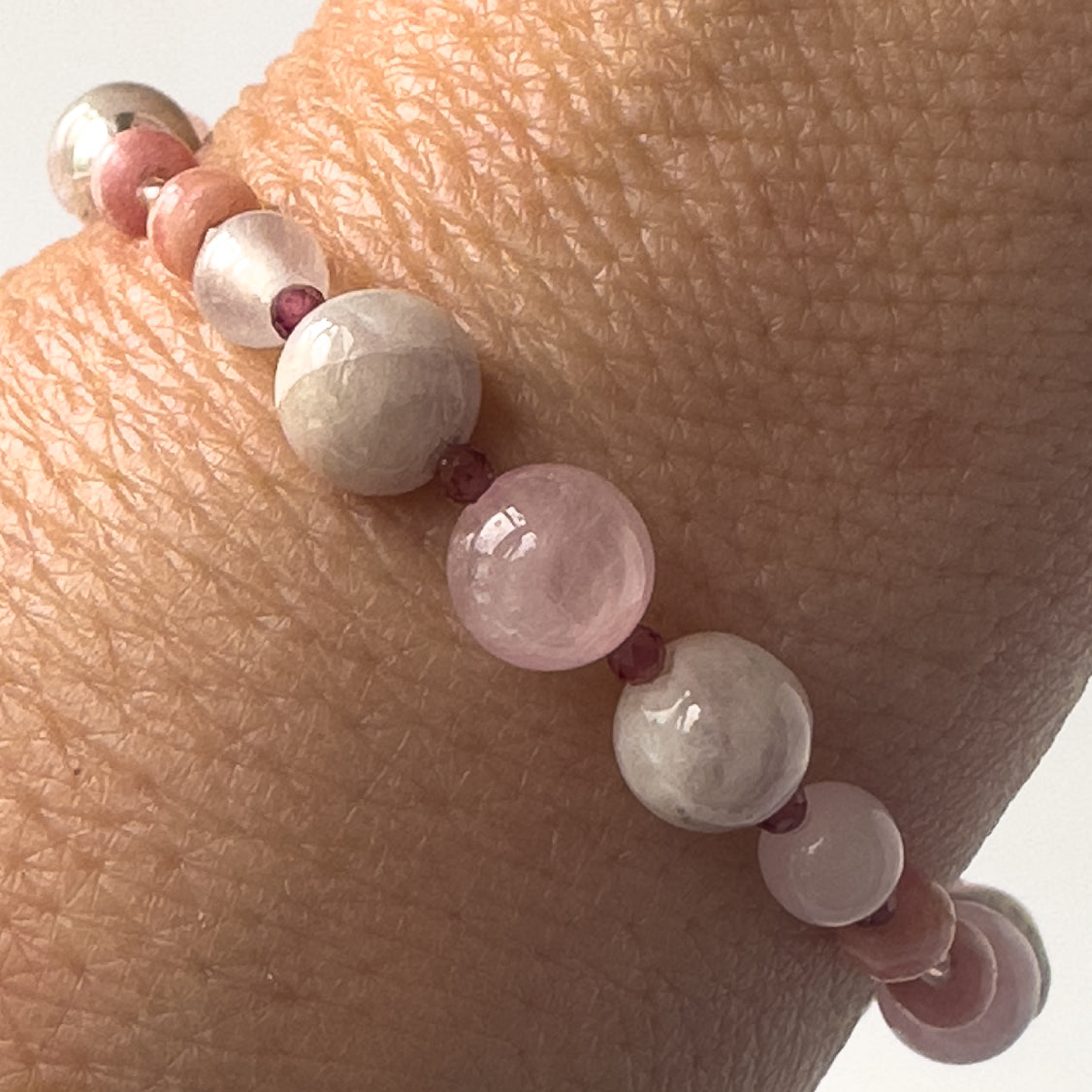 Leo Birthstone Healing Crystal bracelet for Love and Compassion on wrist showing Rose Quartz, Garnet, Kunzite, Rhodochrosite and Ruby