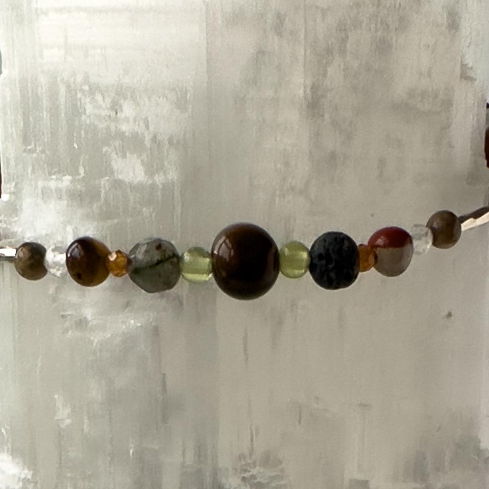 Leo Birthstone Healing Crystal bracelet for Calm & Stress relief showing Blue Tiger’s Eye, Yellow Tiger’s Eye, Peridot, Garnet, Bloodstone, Clear Quartz and Lava Stone