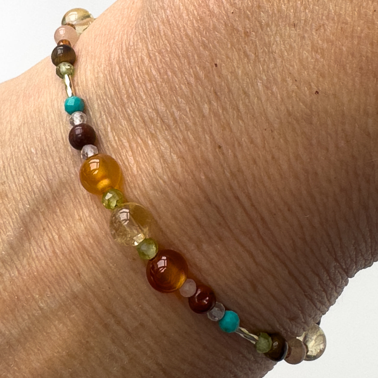 Leo Healing Crystal bracelet for Willpower on wrist showing Carnelian, Tiger’s Eye, Peridot, Citrine, Turquoise, and Clear Quartz