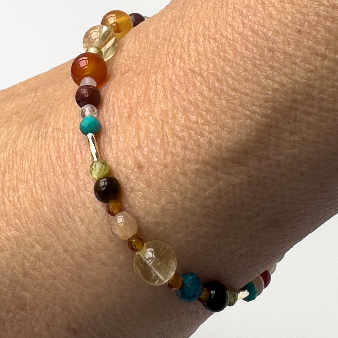 Leo Birthstone Healing Crystal bracelet for Determination & Willpower on wrist showing Carnelian, Tiger’s Eye, Peridot, Citrine, Garnet, Sunstone and Turquoise