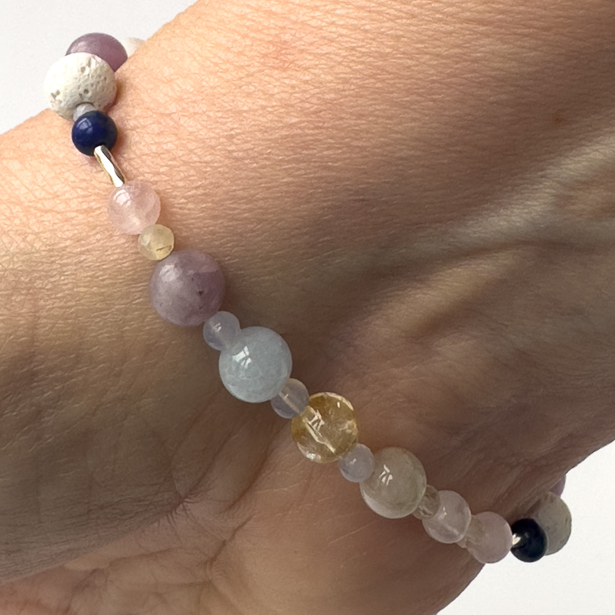 Libra Birthstone Healing Crystal bracelet for Calm & Anxiety Relief on wrist showing Rose Quartz, Lapis Lazuli, Aquamarine, Citrine, Blue Lace Agate, Lepidolite and Moonstone