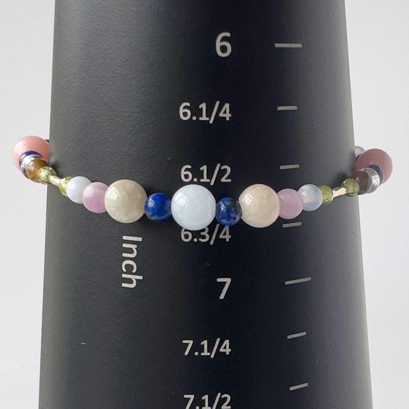 Libra Birthstone Healing Crystal bracelet for Calm & Stress relief on mandrel showing Peridot, Rose Quartz, Lapis Lazuli, Aquamarine, Blue Lace Agate and Kunzite