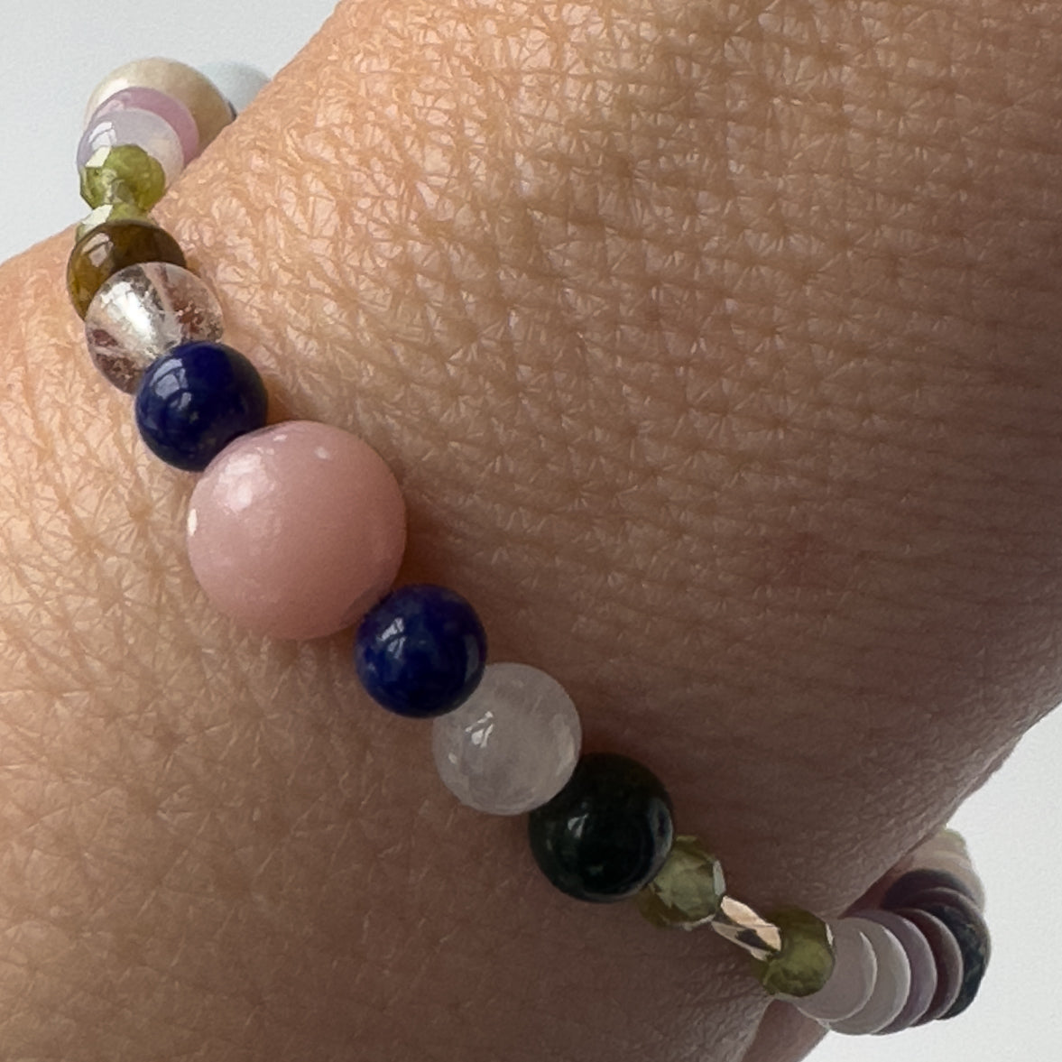 Libra Birthstone Healing Crystal bracelet for Calm & Stress relief on wrist showing Pink Opal, Peridot, Lapis Lazuli, Yellow Tiger’s Eye, Selenite and Clear Quartz