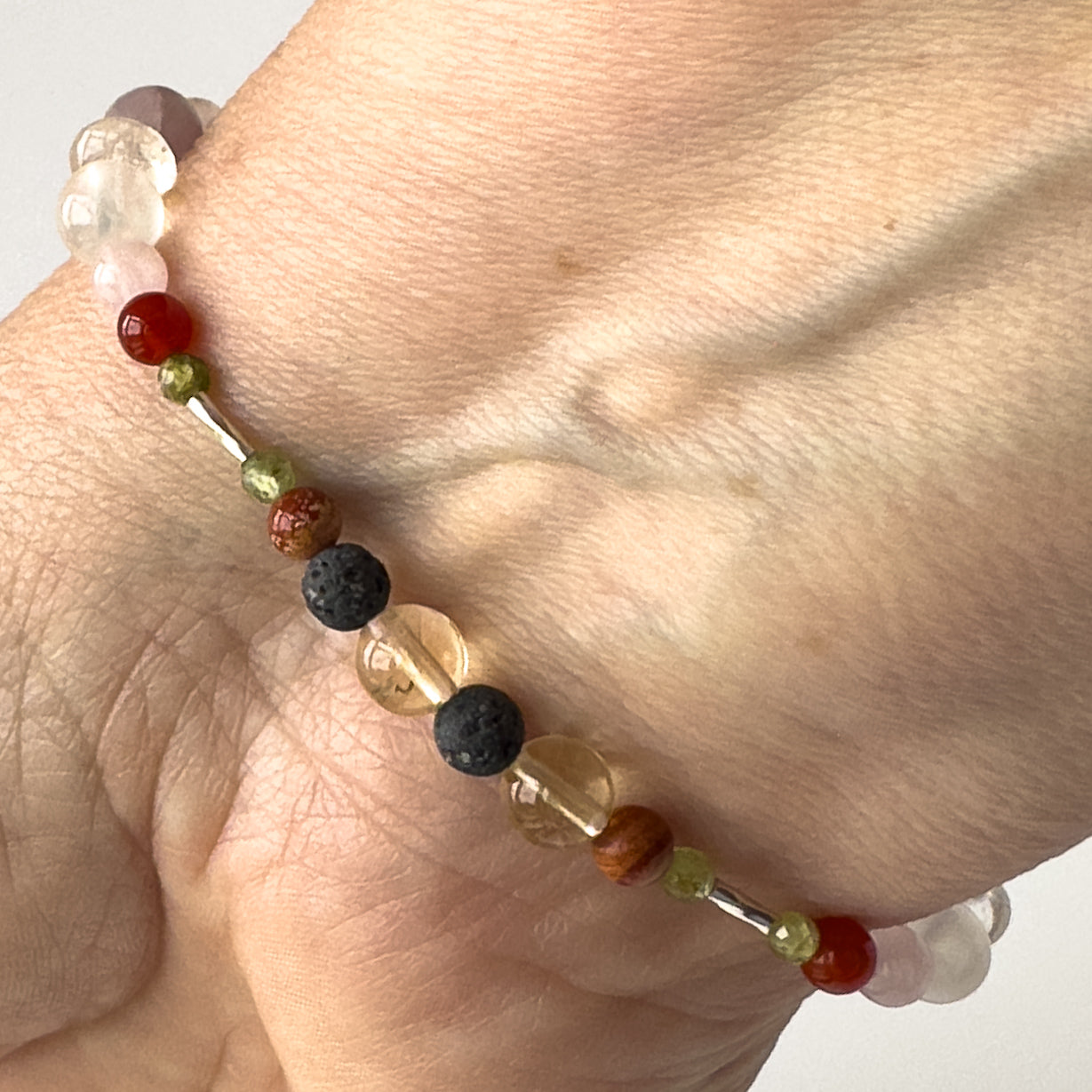 Libra Birthstone Healing Crystal bracelet for Determination & Willpower on wrist showing Citrine, Peridot, Brecciated Jasper and Lava Stone