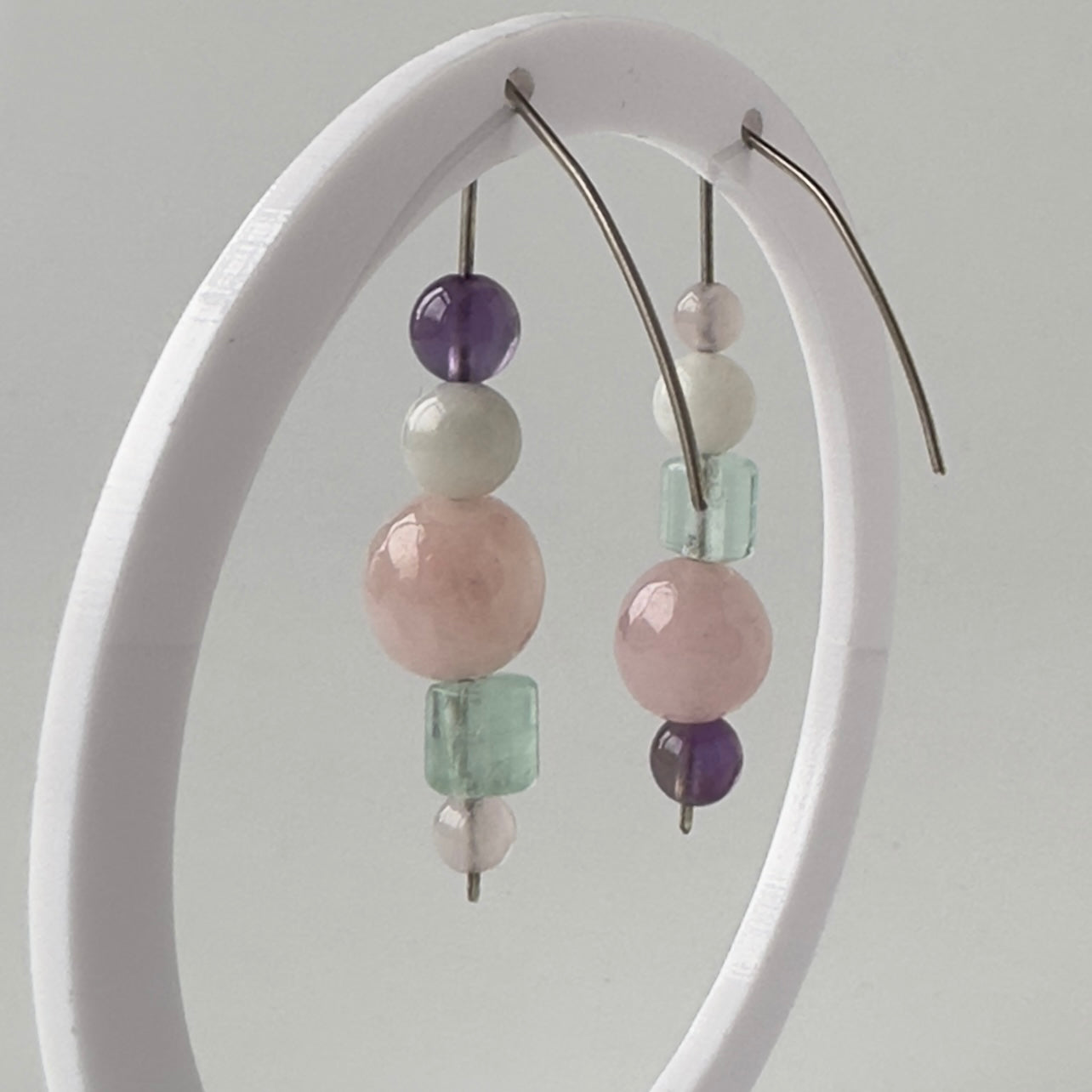 Earrings with multicolored beads on a white arch