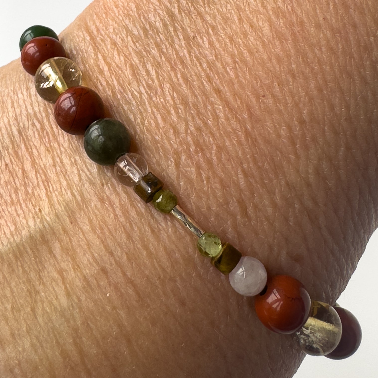 Pisces Healing Crystal bracelet for Love on wrist showing Rose Quartz, Citrine, Peridot, Jade, Red Jasper and Tiger’s Eye
