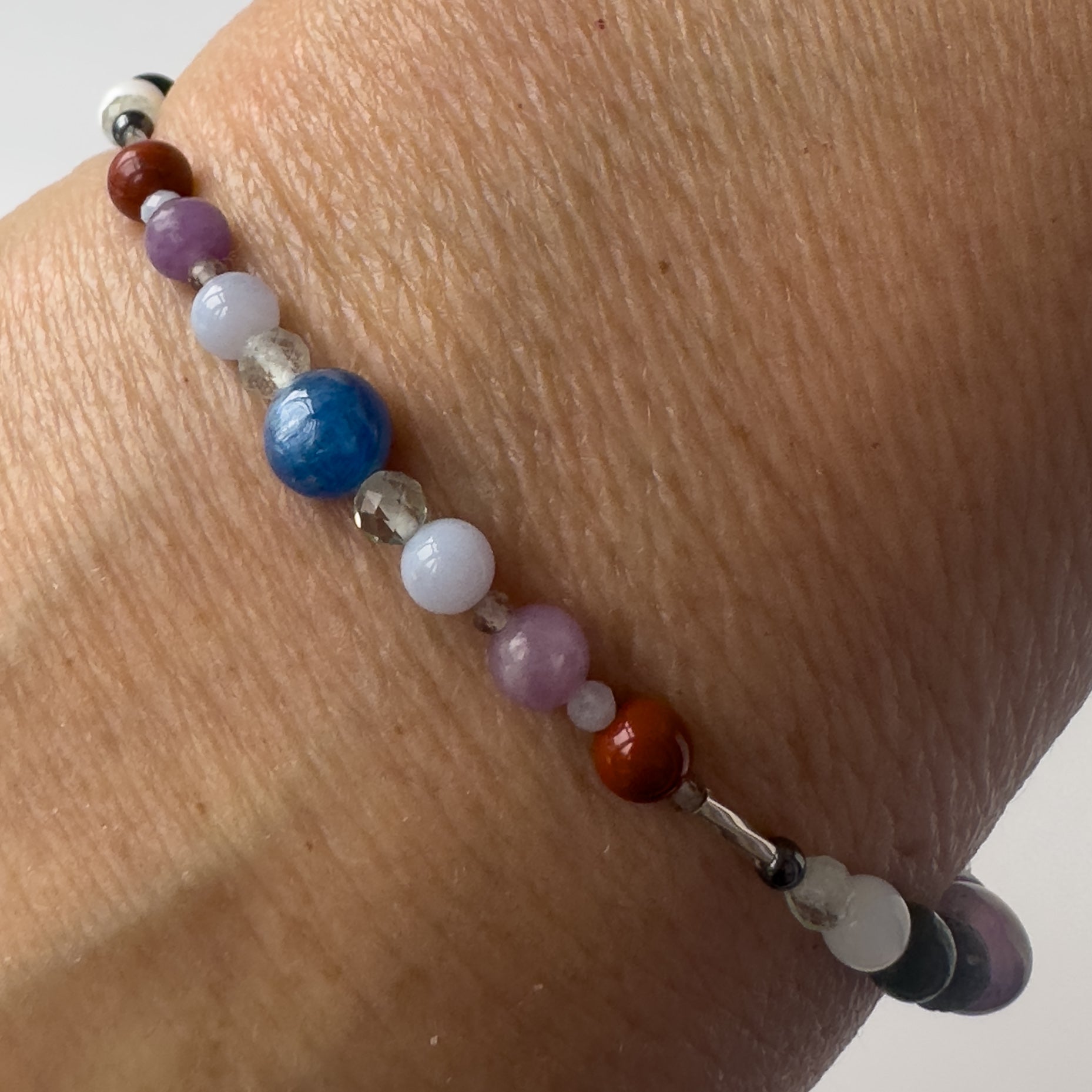 Pisces Healing Crystal bracelet for Stress on wrist showing Lepidolite, Blue Lace Agate, Smoky Quartz, Jasper and Kyanite