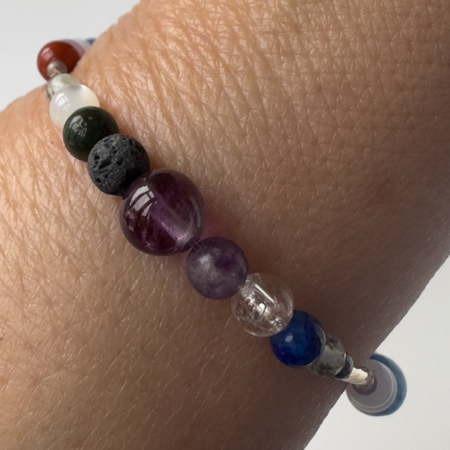 Pisces Birthstone Healing Crystal bracelet for Calm & Stress on wrist showing Amethyst, Lepidolite, Lapis Lazuli, Moonstone and Clear Quartz