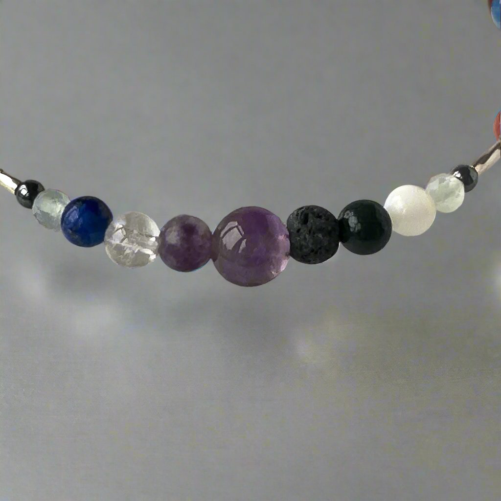 Pisces Birthstone Healing Crystal bracelet for Calm & Stress showing Amethyst, Lepidolite, Hematite, Blue Lace Agate, Lapis Lazuli, Moonstone, Clear Quartz and Lava Stone