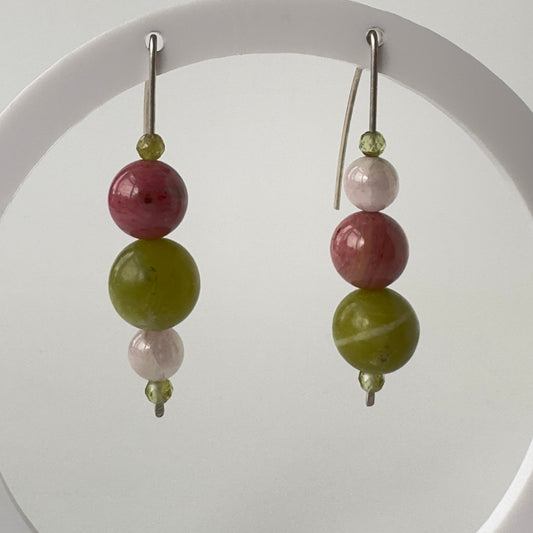 Pair of earrings with green and pink beads on a white background