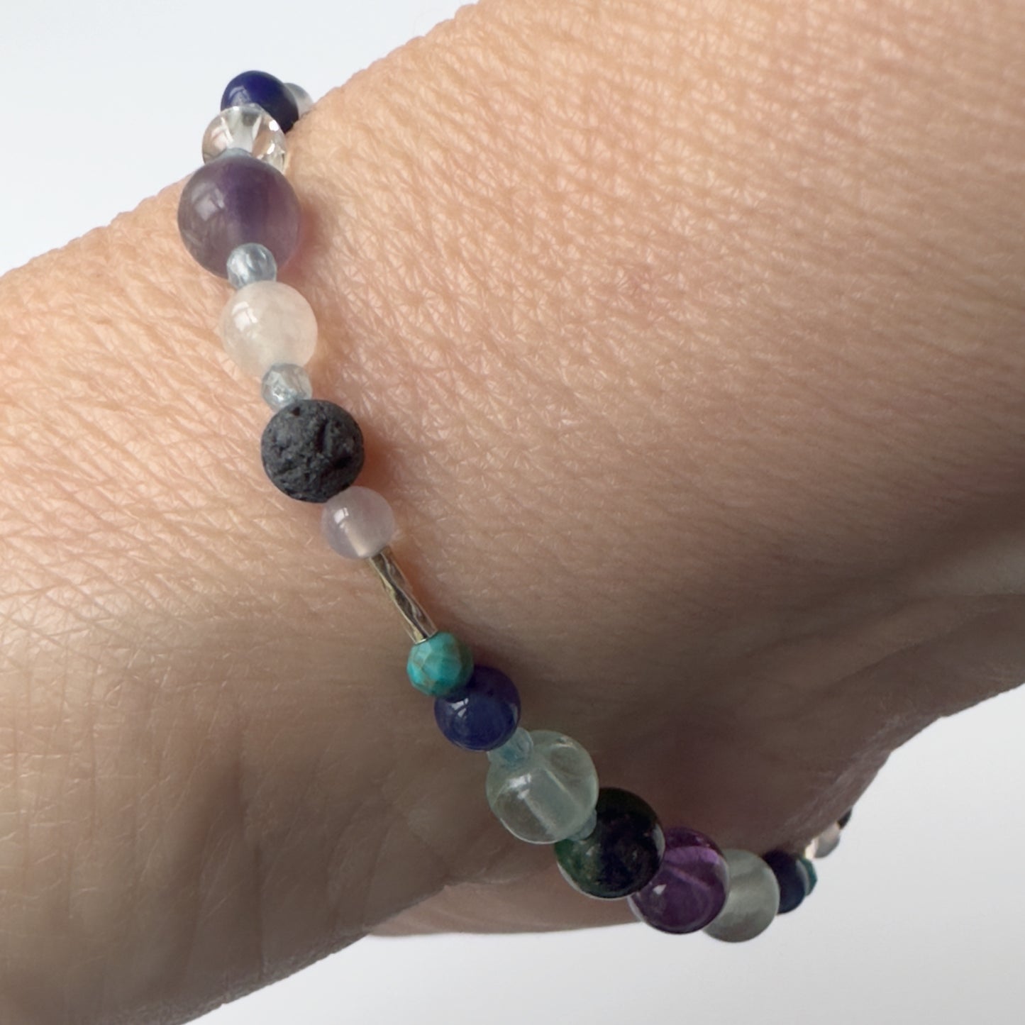 Sagittarius Birthstone Healing Crystal bracelet for Calm & Anxiety Relief on wrist showing Turquoise, Amethyst, Lapis Lazuli, Azurite, Blue Topaz, Fluorite, Selenite, Clear Quartz and Lava Stone
