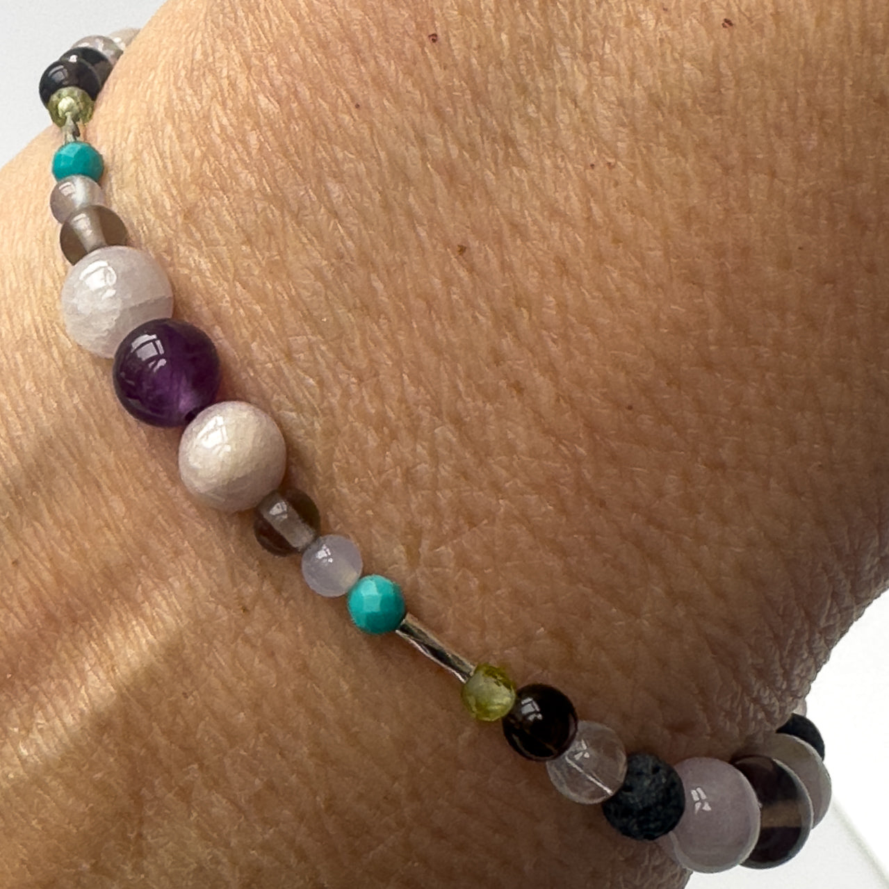 Scorpio Healing Crystal bracelet for Anxiety on wrist showing Turquoise, Blue Lace Agate, Amethyst, Smoky Quartz, Peridot, Kunzite, Selenite and Clear Quartz