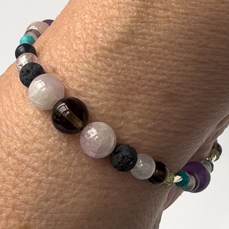 Scorpio Birthstone Healing Crystal bracelet for Calm & Anxiety Relief on wrist showing Turquoise, Blue Lace Agate, Smoky Quartz, Peridot, Hematite and Kunzite