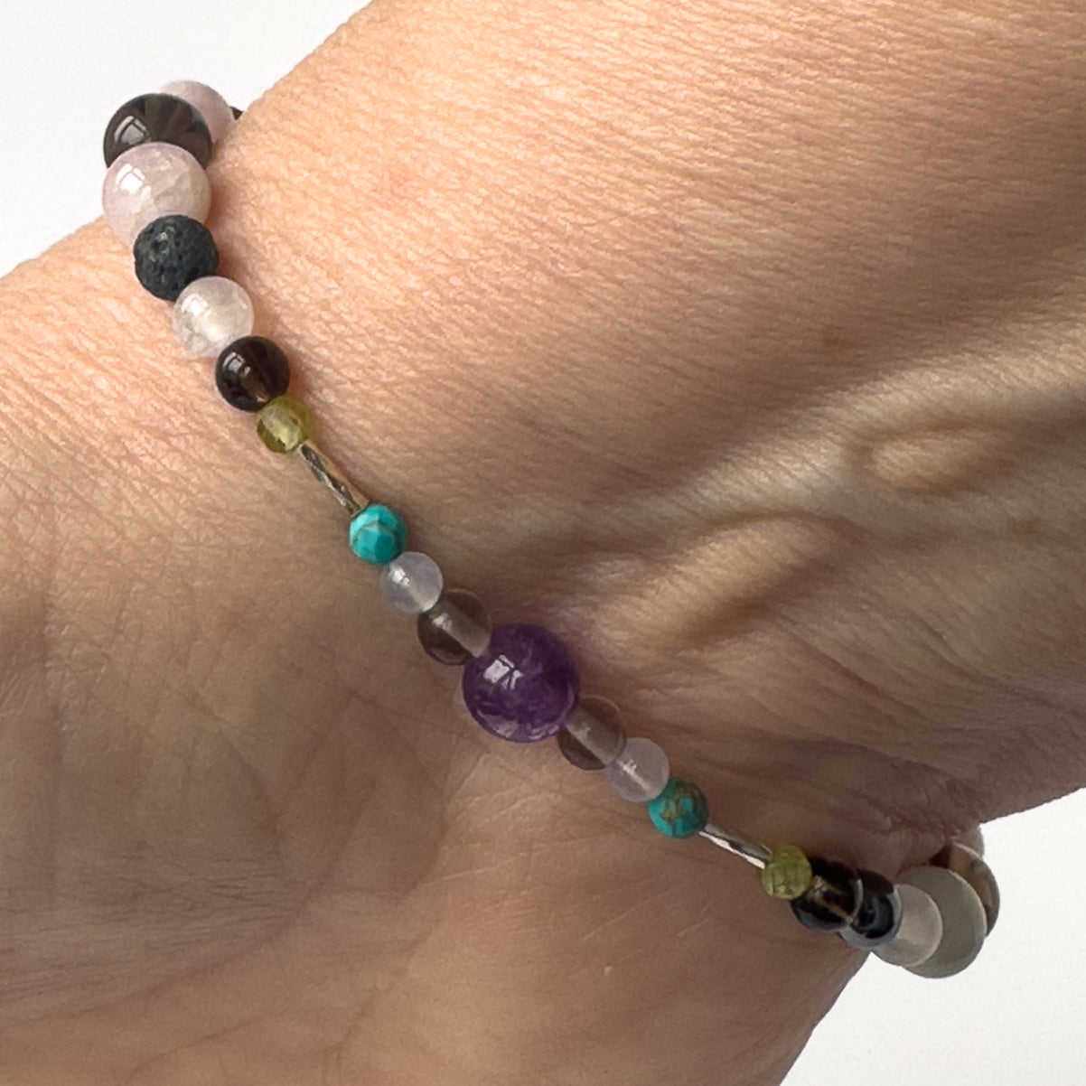 Scorpio Birthstone Healing Crystal bracelet for Calm & Anxiety Relief on wrist showing Turquoise, Blue Lace Agate, Smoky Quartz, Peridot, Hematite and Kunzite