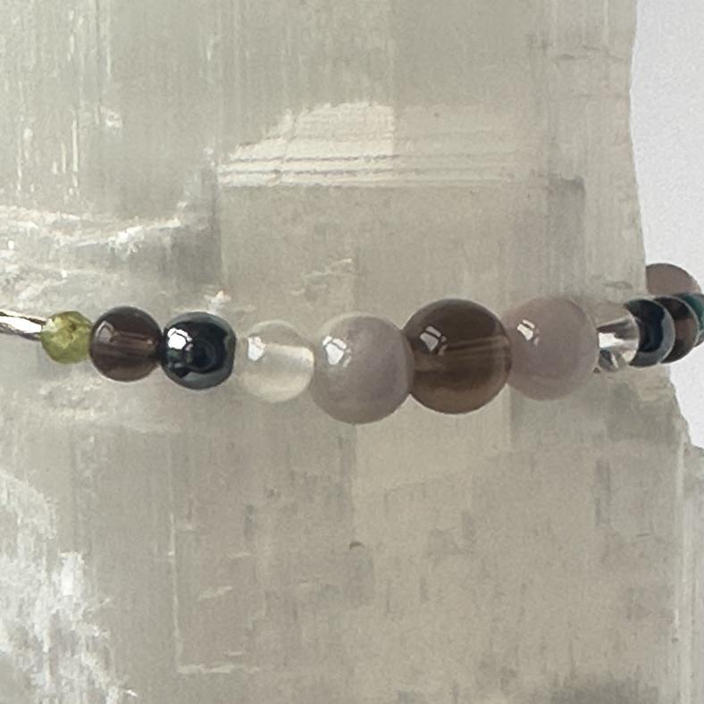 Scorpio Birthstone Healing Crystal bracelet for Calm & Anxiety Relief showing Smoky Quartz, Peridot, Hematite, Kunzite, Selenite and Clear Quartz