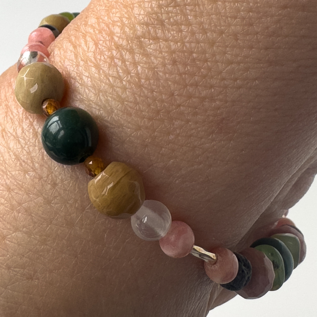 Scorpio birthstone Healing Crystal bracelet for Love and Compassion on wrist showing Moss Agate, Garnet, Rhodochrosite, Rhodonite and Selenite